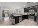 Well-lit kitchen featuring dark cabinetry, stainless steel appliances, and an open concept design at 17038 W Mohave St, Goodyear, AZ 85338