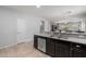 Spacious kitchen features dark cabinets, stainless steel appliances, granite countertops, and a tile floor at 17038 W Mohave St, Goodyear, AZ 85338