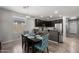 Open kitchen and dining area features matching dark wood table, cabinets, and stainless steel appliances at 17038 W Mohave St, Goodyear, AZ 85338