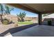 Landscaped backyard with a stone-covered area, small patch of grass, and mature trees at 17154 W Las Palmaritas Dr, Waddell, AZ 85355