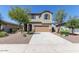 Charming two-story house with desert landscaping, a wide driveway, and a welcoming facade at 17154 W Las Palmaritas Dr, Waddell, AZ 85355