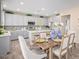 Stylish kitchen with gray cabinetry, an island with seating, and an adjoining dining space at 17154 W Las Palmaritas Dr, Waddell, AZ 85355