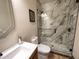 Updated bathroom featuring sleek vanity, modern toilet, and glass-enclosed shower with marble tile at 17658 N 52Nd Pl, Scottsdale, AZ 85254