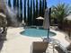 Backyard pool with basketball hoop, lounge chairs, patio umbrella, and misting system surrounded by tall evergreen trees at 17658 N 52Nd Pl, Scottsdale, AZ 85254