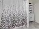 Bathroom showcases tiled shower with patterned curtain, white cabinet with shelves at 17946 W Via Del Sol --, Surprise, AZ 85387