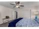 Bedroom with a ceiling fan, a bed with blue floral bedding, and a glass table at 17946 W Via Del Sol --, Surprise, AZ 85387