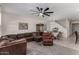 Cozy living room features a large sectional, ceiling fan, and transition to the dining room with tile flooring at 17946 W Via Del Sol --, Surprise, AZ 85387