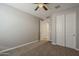 Bedroom featuring neutral carpet and paint, sliding-door closet, and a ceiling fan for optimal comfort at 18766 N Salerno Dr, Maricopa, AZ 85138
