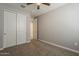 Bedroom featuring neutral carpet and paint, sliding-door closet, and a ceiling fan for optimal comfort at 18766 N Salerno Dr, Maricopa, AZ 85138
