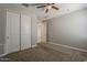 Bedroom featuring neutral carpet and paint, sliding-door closet, and a ceiling fan for optimal comfort at 18766 N Salerno Dr, Maricopa, AZ 85138