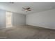 Large bedroom featuring neutral paint, carpeted floor, ceiling fan, and an attached bathroom with a shower at 18766 N Salerno Dr, Maricopa, AZ 85138