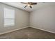 Bedroom featuring neutral carpet and paint, and a bright window with blinds to let in natural light at 18766 N Salerno Dr, Maricopa, AZ 85138