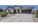 View of the charming single-story home featuring a two-car garage and desert landscaping at 18766 N Salerno Dr, Maricopa, AZ 85138