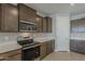 Modern kitchen with stainless steel appliances, brown cabinets and white countertops at 18766 N Salerno Dr, Maricopa, AZ 85138