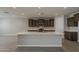 Bright kitchen featuring a large island, stainless steel appliances, and dark brown cabinetry at 18766 N Salerno Dr, Maricopa, AZ 85138