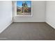 An empty bedroom with soft carpet and a window view of the neighborhood at 1901 E Hearn Rd, Phoenix, AZ 85022