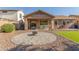 Backyard featuring an inviting patio area with desert landscaping and a built-in firepit at 19318 E Reins Rd, Queen Creek, AZ 85142