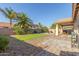 Lush backyard showcasing desert landscaping with patio, desert trees and artificial turf at 19318 E Reins Rd, Queen Creek, AZ 85142