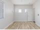 A large, well-lit bedroom featuring two small windows and laminate flooring at 19318 E Reins Rd, Queen Creek, AZ 85142