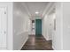 Bright foyer with wood-look floors, a teal door, and decorative wall trim at 19318 E Reins Rd, Queen Creek, AZ 85142