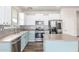 Updated kitchen with stainless steel appliances, white cabinets, and a light blue island at 19318 E Reins Rd, Queen Creek, AZ 85142