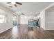 Open-concept living room and kitchen with wood floors, stainless steel appliances, and two ceiling fans at 19318 E Reins Rd, Queen Creek, AZ 85142