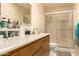 Well-lit bathroom featuring a shower with glass doors, a vanity, and ample storage space at 1951 E Del Sur Dr, Tempe, AZ 85283