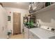 Functional laundry room with washer, dryer, shelving, and access door at 1951 E Del Sur Dr, Tempe, AZ 85283