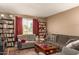 Cozy living room featuring comfortable seating, a window with blinds, and bookshelves, perfect for relaxing and reading at 1951 E Del Sur Dr, Tempe, AZ 85283