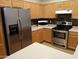 Modern kitchen with stainless steel appliances, light wood cabinets, and light countertops at 1970 W Park Pl, Chandler, AZ 85224