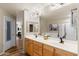 Bathroom featuring double sinks with wood cabinetry, a soaking tub, and a walk-in shower at 19700 N 76Th St # 1038, Scottsdale, AZ 85255