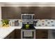 A close up of the stainless steel stove, microwave, and white countertops in the modern kitchen at 19700 N 76Th St # 1038, Scottsdale, AZ 85255