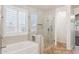 Beautiful bathroom with tiled floors, shower, soaker tub, and modern finishes at 20226 N Madison Dr, Maricopa, AZ 85138