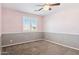Bedroom with pink upper walls and grey lower walls, neutral carpet, ceiling fan, and window at 20226 N Madison Dr, Maricopa, AZ 85138