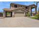 Two-story home featuring desert landscaping, a three-car garage, and a covered patio at 20226 N Madison Dr, Maricopa, AZ 85138