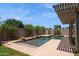 Backyard pool is surrounded by mature landscaping, lush plants, and a privacy fence at 20226 N Madison Dr, Maricopa, AZ 85138
