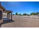 Spacious backyard featuring a covered patio, gravel landscaping, and white fencing at 20911 E Excelsior Ave, Queen Creek, AZ 85142