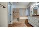 Bright bathroom featuring an ornate mirror, double sinks, a soaking tub, and a separate tiled shower at 20911 E Excelsior Ave, Queen Creek, AZ 85142
