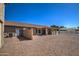 Rear exterior of home featuring a covered patio and spacious gravel backyard at 20911 E Excelsior Ave, Queen Creek, AZ 85142