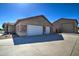 Spacious three-car garage with white doors and a concrete driveway offers ample parking and storage space at 20911 E Excelsior Ave, Queen Creek, AZ 85142