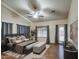 This is a stunning primary bedroom featuring hardwood floors, a ceiling fan and beautiful furnishings at 20911 E Excelsior Ave, Queen Creek, AZ 85142