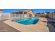Sparkling blue pool with surrounding concrete deck, white fencing, and lush landscaping for backyard oasis at 20911 E Excelsior Ave, Queen Creek, AZ 85142