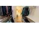 Walk-in closet with built-in shelving and hanging rods, leading to a bathroom at 23771 W Yavapai St, Buckeye, AZ 85326