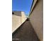 A gravel side yard with a block wall and a view of neighboring homes under a clear blue sky at 23771 W Yavapai St, Buckeye, AZ 85326