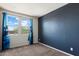 Bedroom with large window and blue accent wall at 2410 S 124Th Dr, Avondale, AZ 85323