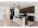 Well-equipped kitchen boasts a granite island, dark cabinetry, and stainless steel appliances at 2410 S 124Th Dr, Avondale, AZ 85323