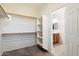 Walk-in closet with shelves and rods leading to a bathroom at 2410 S 124Th Dr, Avondale, AZ 85323