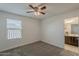 A bedroom with neutral carpet, ceiling fan and window with blinds allowing natural light at 25155 N 108Th Ave, Peoria, AZ 85383