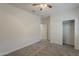 Bright bedroom with carpet, a ceiling fan, closet and ensuite bathroom doors at 25155 N 108Th Ave, Peoria, AZ 85383