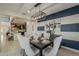 Dining room with open concept kitchen, modern light fixture, and striped accent wall at 25155 N 108Th Ave, Peoria, AZ 85383
